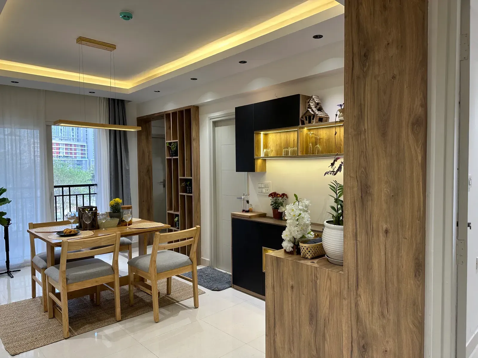 Open living and dining area with oak joinery and cove lighting — The Aakar